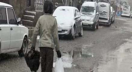 Delik ayakkabısı kardan korumak için ayaklarına poşet giyiyor